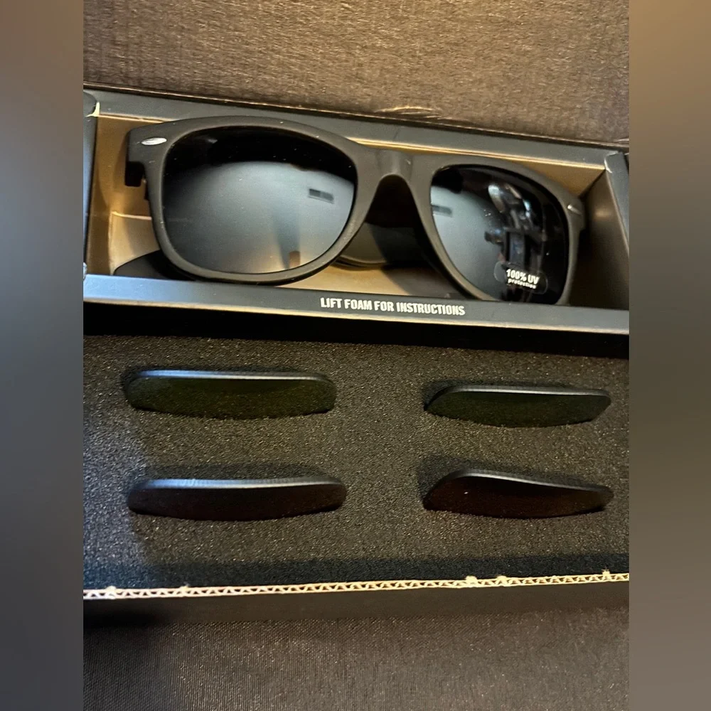 Sunglasses with three interchangeable lenses, dark, yellow, and blue.